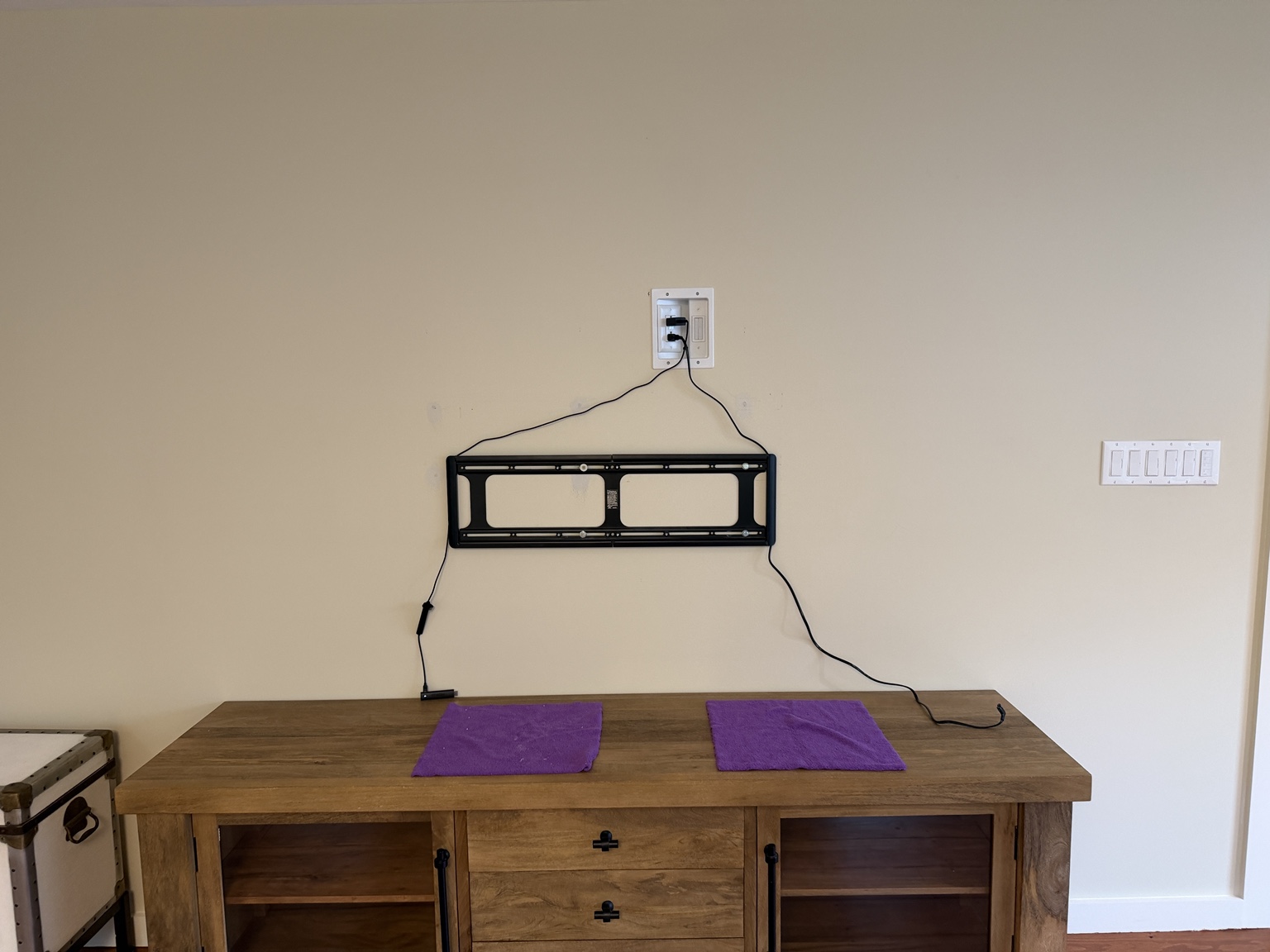 Low-profile TV mount installed below a recessed power and media outlet